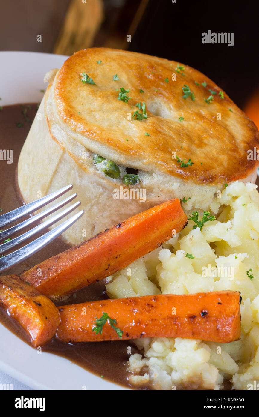 Homemade Chicken and Ham meat pie with carrot, mashed potato and gravy. Stock Photo