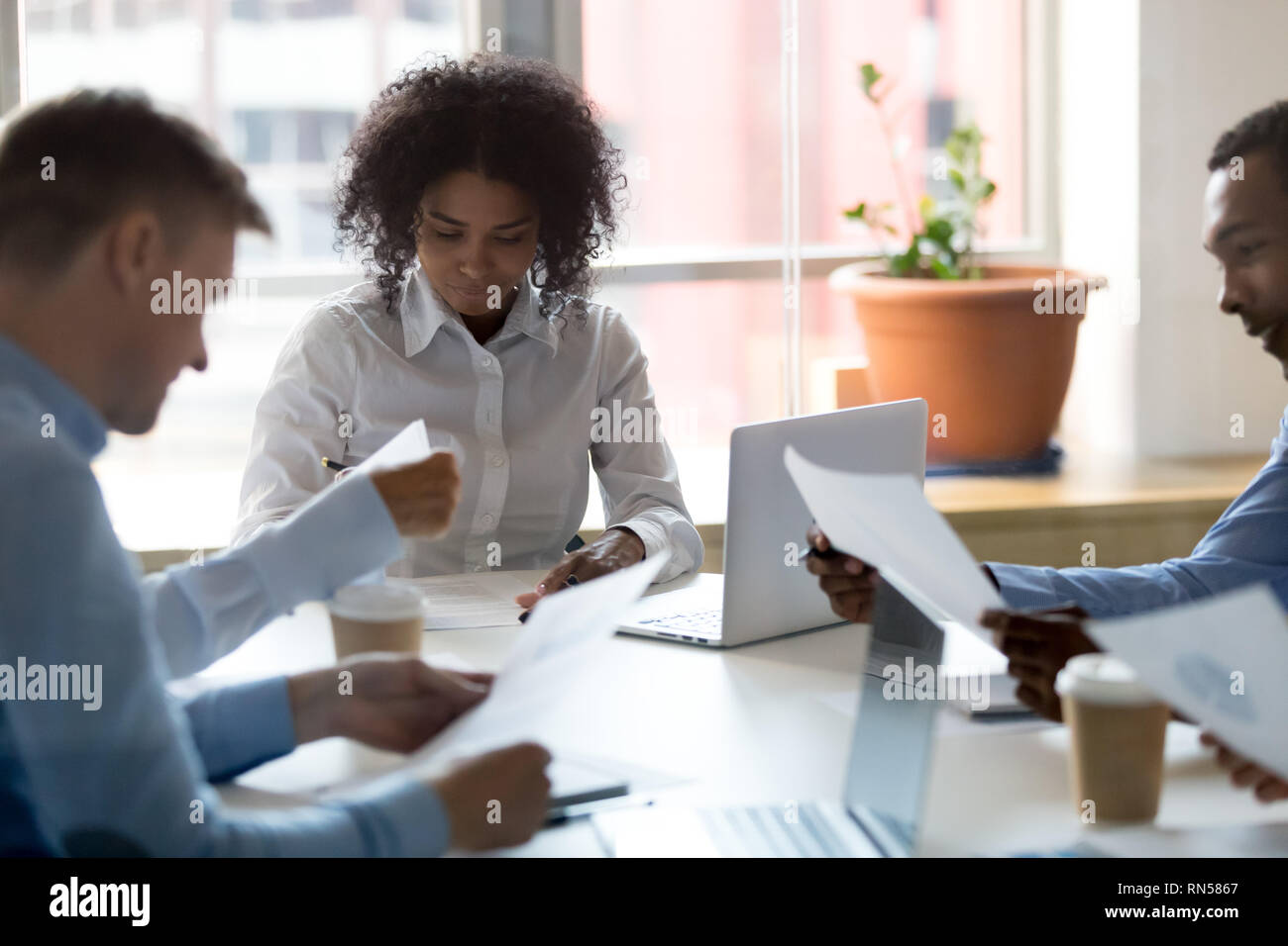 Colleagues analyzing statistics while brainstorming in office together  Stock Photo