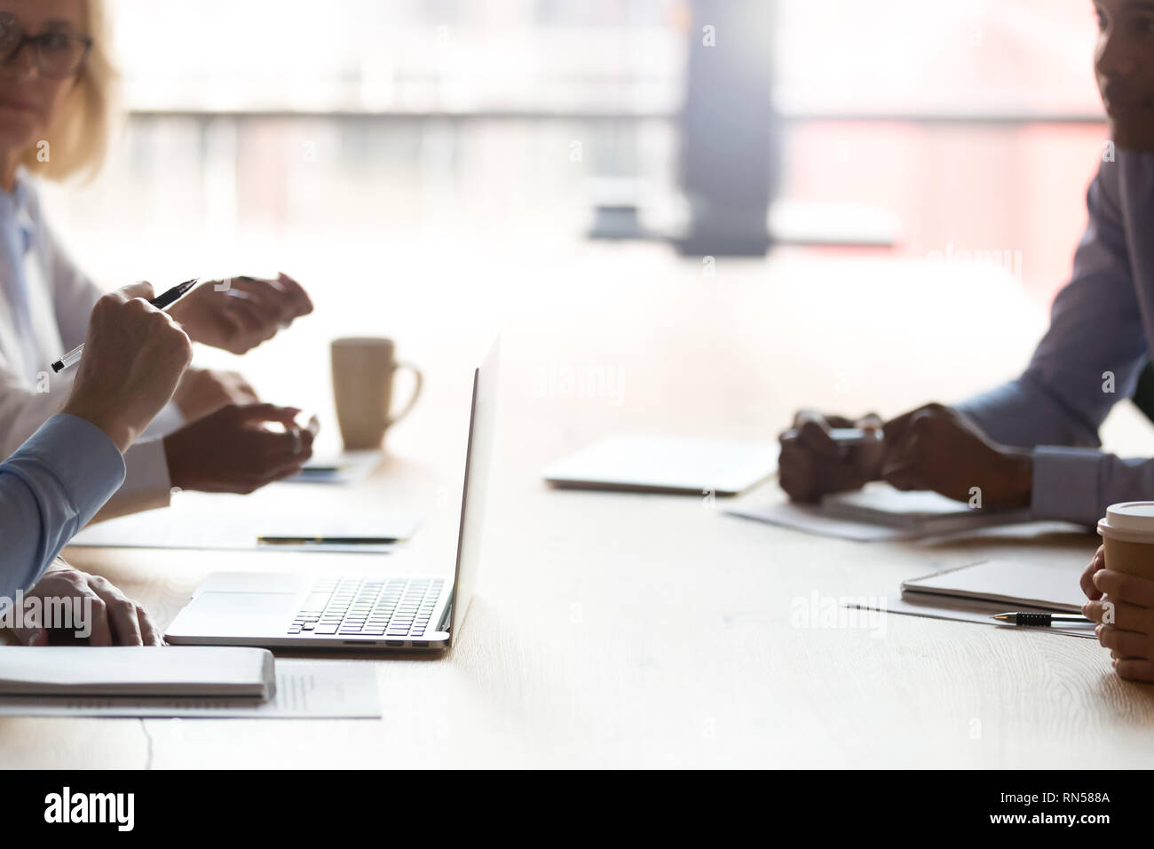 Cropped image businesspeople sitting at table discussing making decisions  Stock Photo