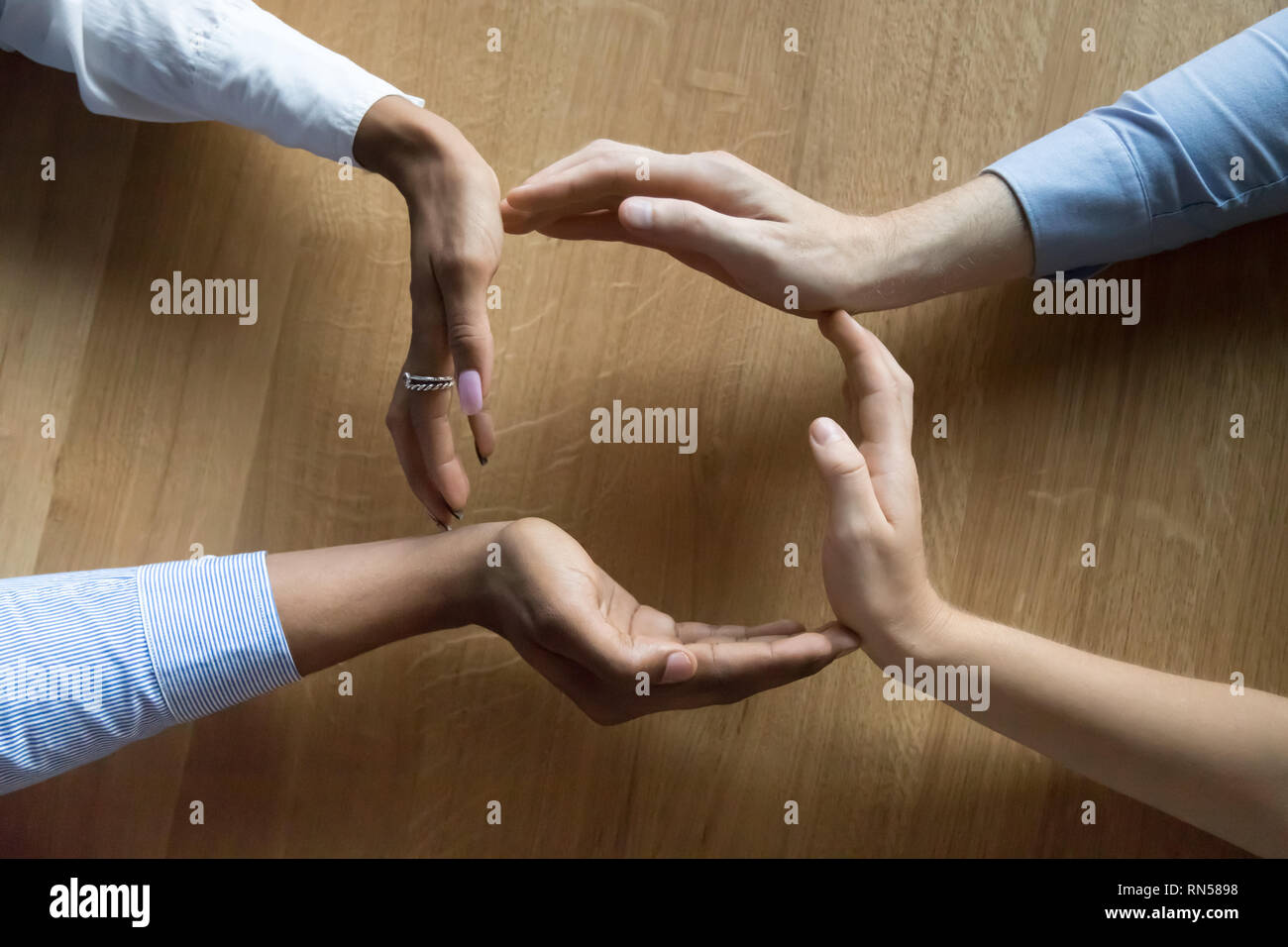 Above closeup view businesspeople hands in shape of circle Stock Photo