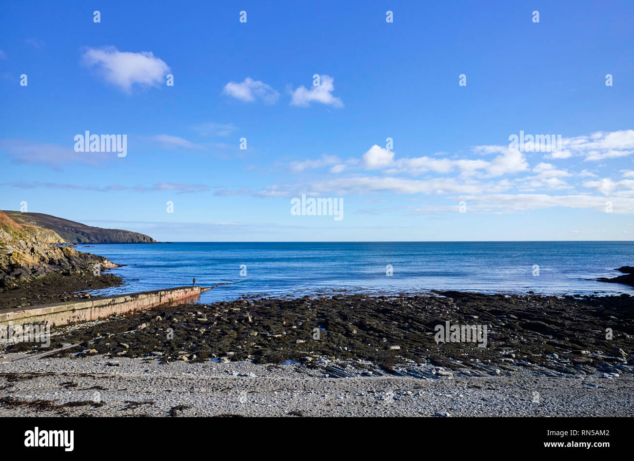Woman standing on the end of a jetty at Port Soderick in the Isle of Man Stock Photo