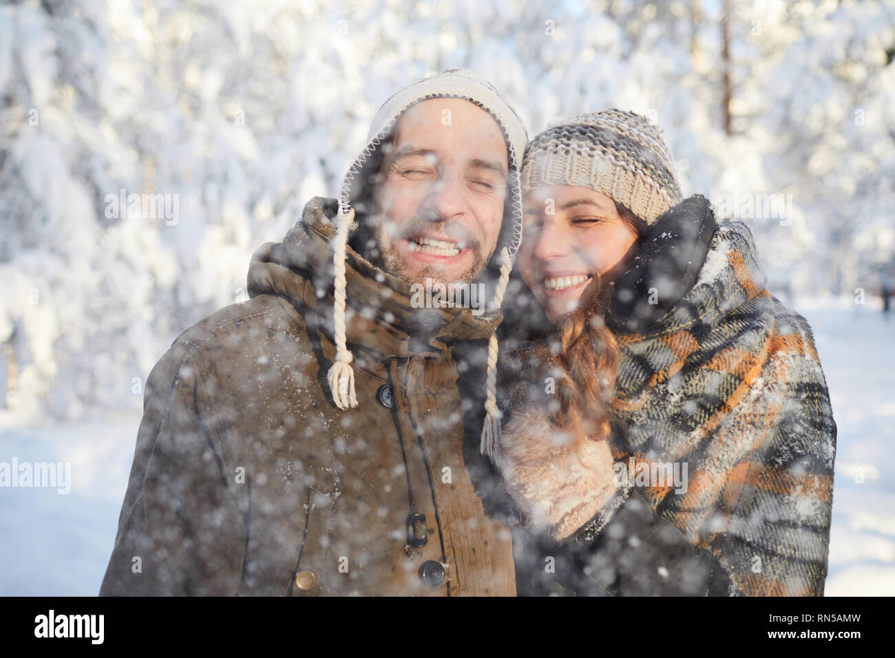 Loving Couple Enjoying Snowfall Stock Photo