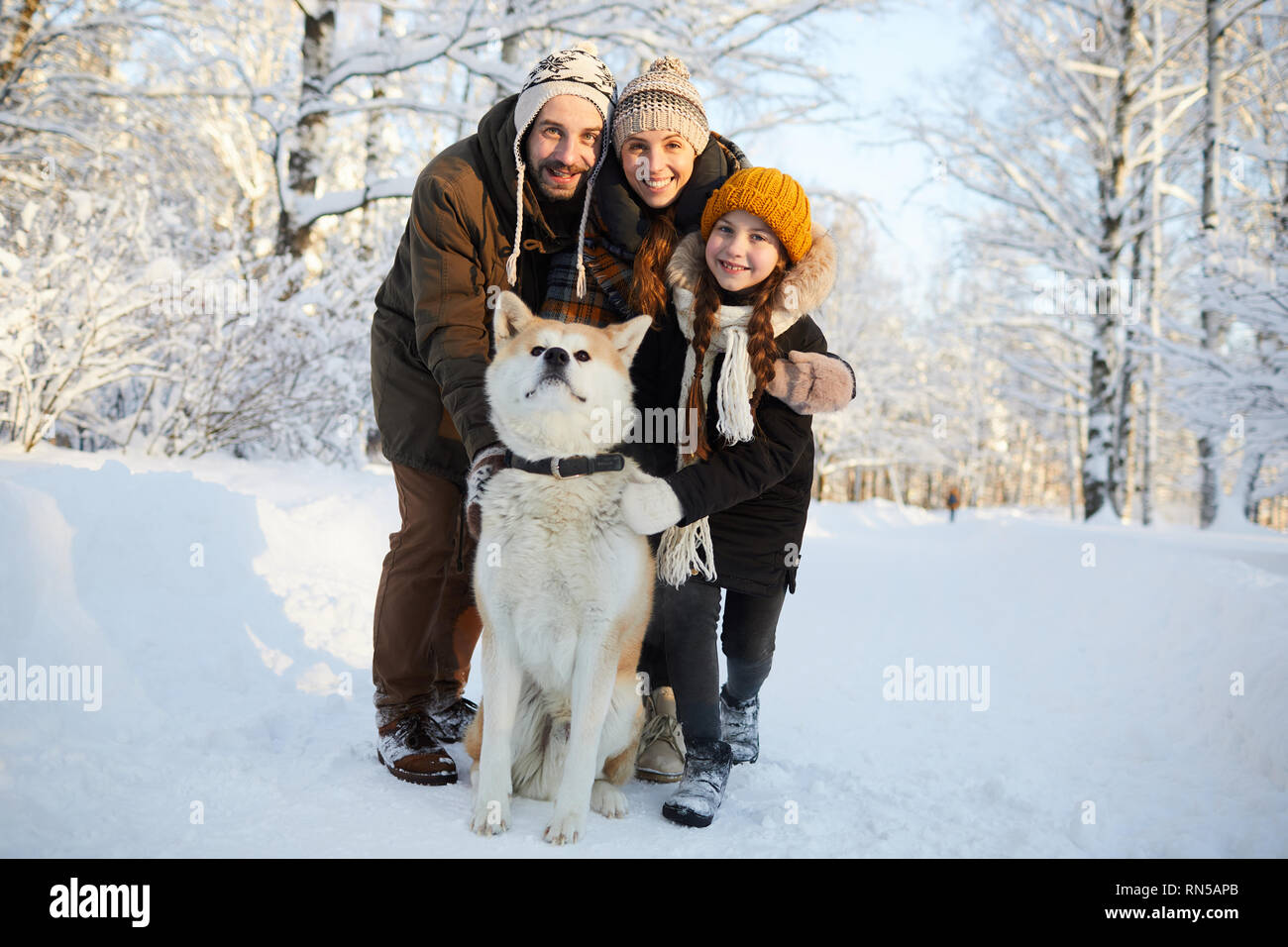 Family Posing with Dog Outdoors Stock Photo