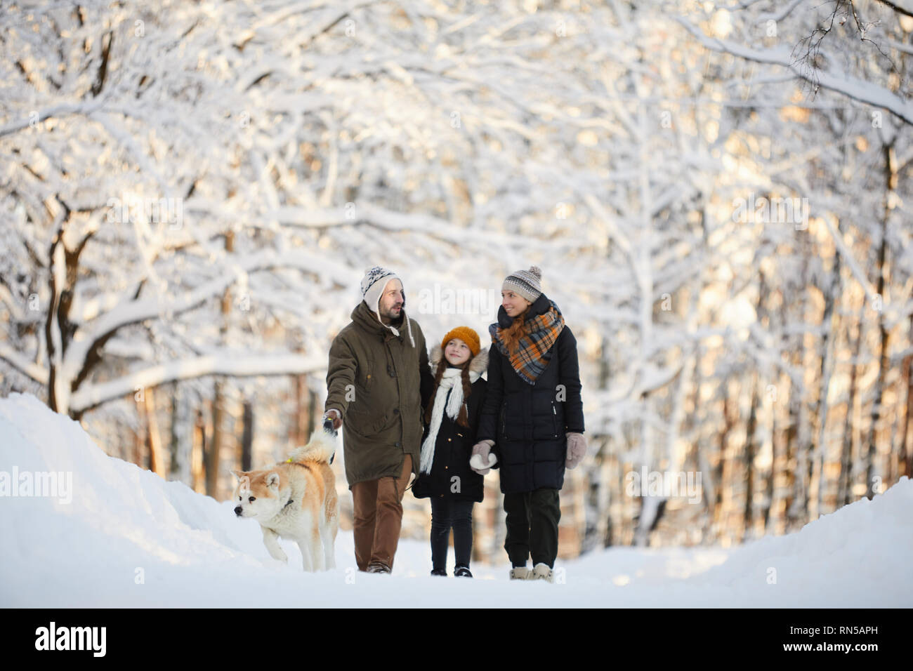 Family Walking Dog in Winter Park Stock Photo