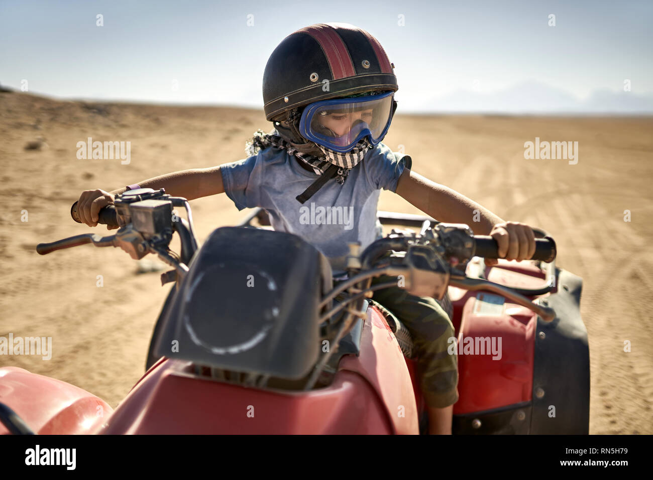Kid in helmet and protect mask riding quad bike Stock Photo Alamy