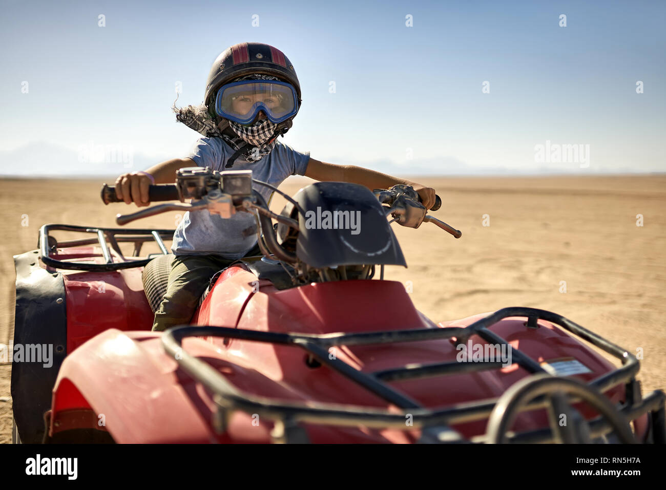 Kid in helmet and protect mask riding quad bike Stock Photo Alamy