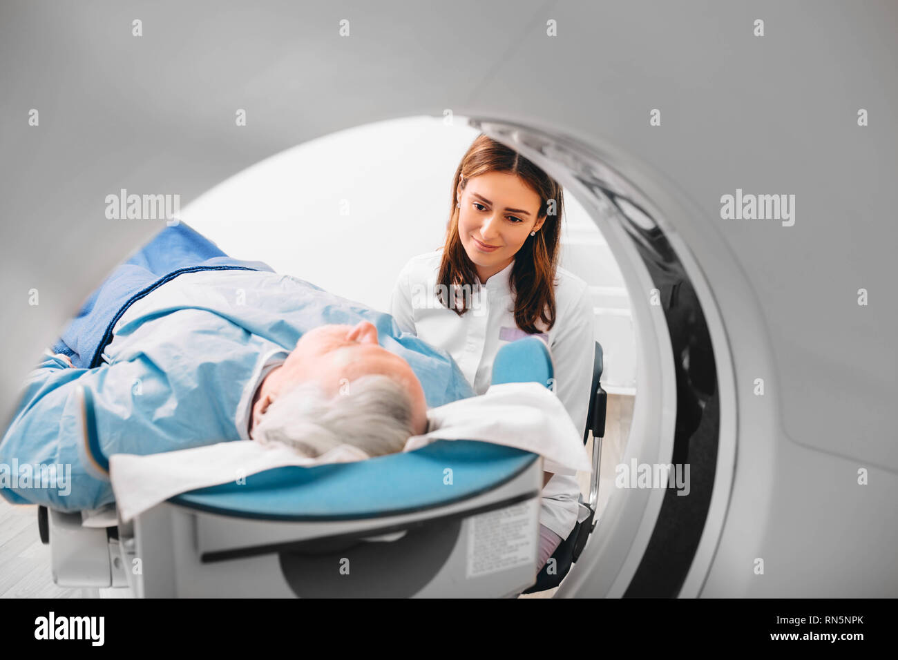 friendly doctor preparing elderly patient for CT Scan in hospital Stock Photo