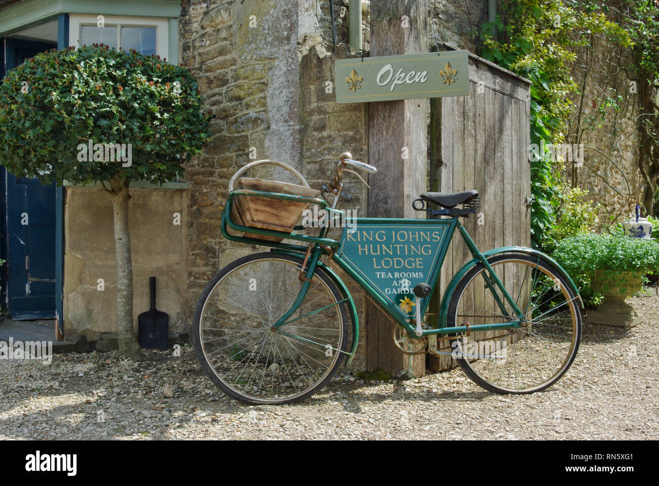 A sign, incorporated into an old bicycle, for King John's Hunting Lodge, tea rooms and restaurant in the historic village of Lacock, UK Stock Photo