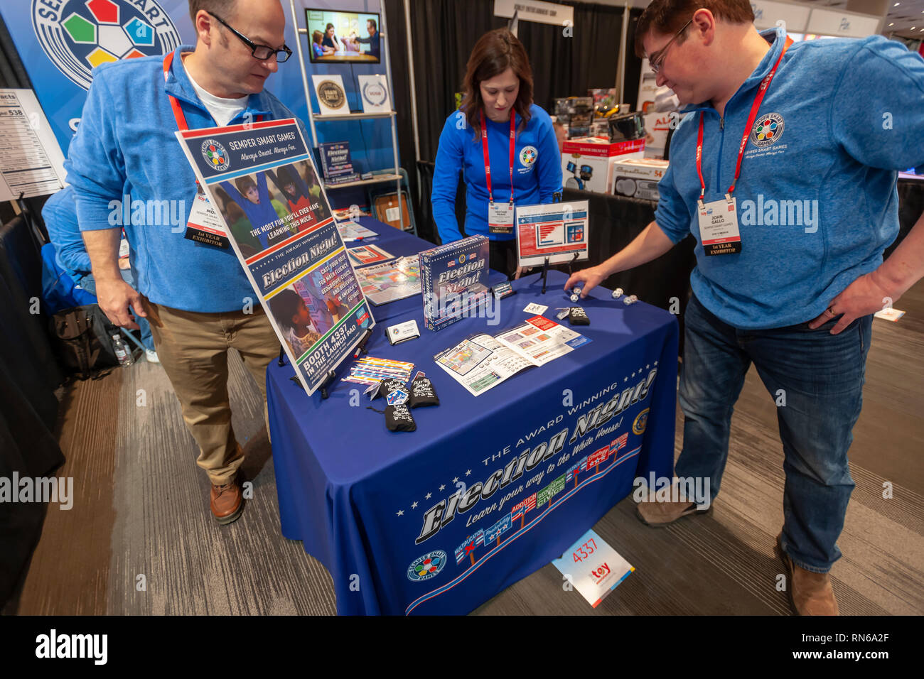 New York, USA. 17th Feb, 2019. Founder Jim Moran, right, with other booth workers neatens up their 'Election Night' game display at the 116th North American International Toy Fair in the Jacob Javits Convention center in New York on Sunday, February 17, 2019. Semper Smart Games creates math oriented games. 'ElectionNight' teaches children about the Electoral College' and the math of winning an election. ( © Richard B. Levine) Credit: Richard Levine/Alamy Live News Stock Photo