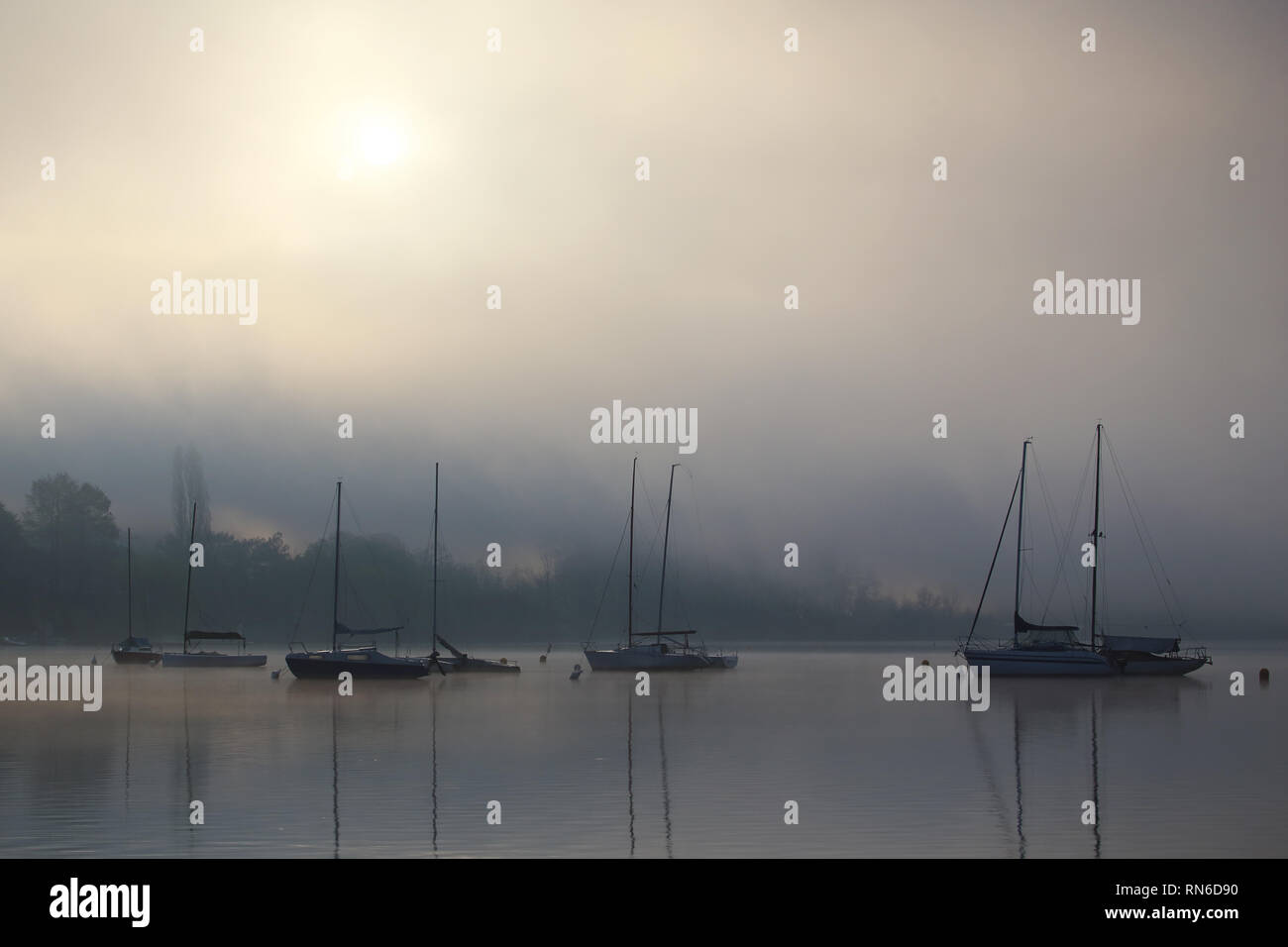 boats that are reflected on the water, in the fog and in the sun Stock ...