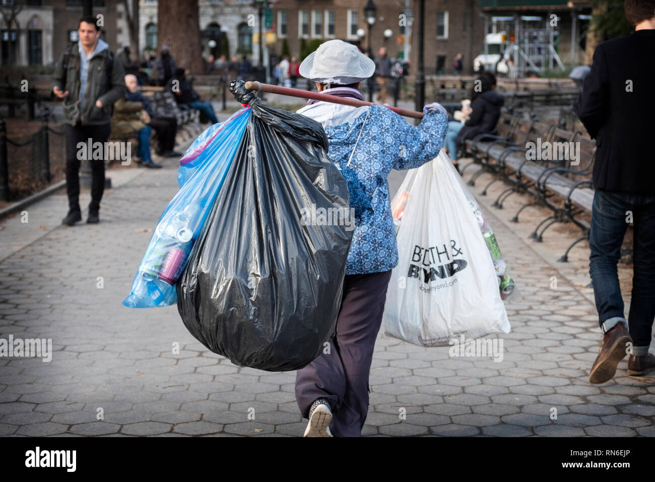 A middle aged Asian woman collecting deposit bottles in Greenwich Village, New York City. Stock Photo