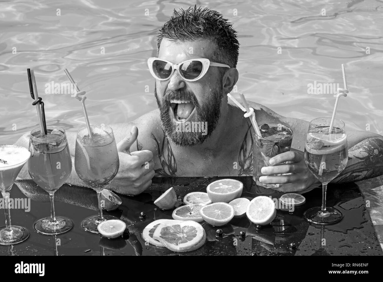Relax at sea and spa resort. Man swimming and drink alcohol. Summer vacation at Miami or Maldives. Pool party, vitamin and dieting. Cocktail with Stock Photo