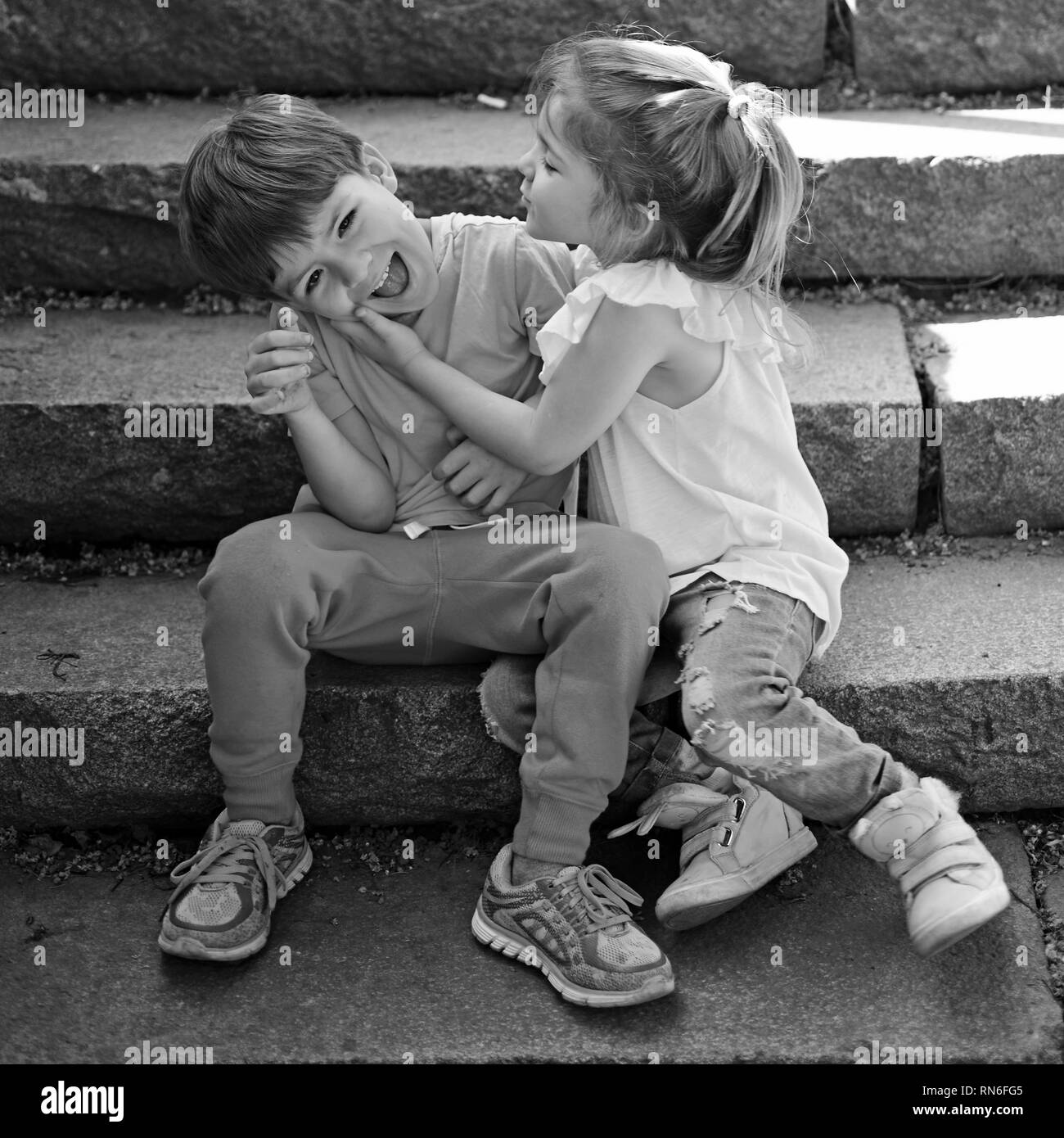 small girl and boy on stairs. Relations. childhood first love ...