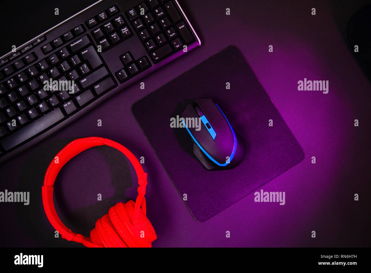 Top view a gaming gear, mouse, keyboard, joystick, headset, VR Headset on black table background. Stock Photo
