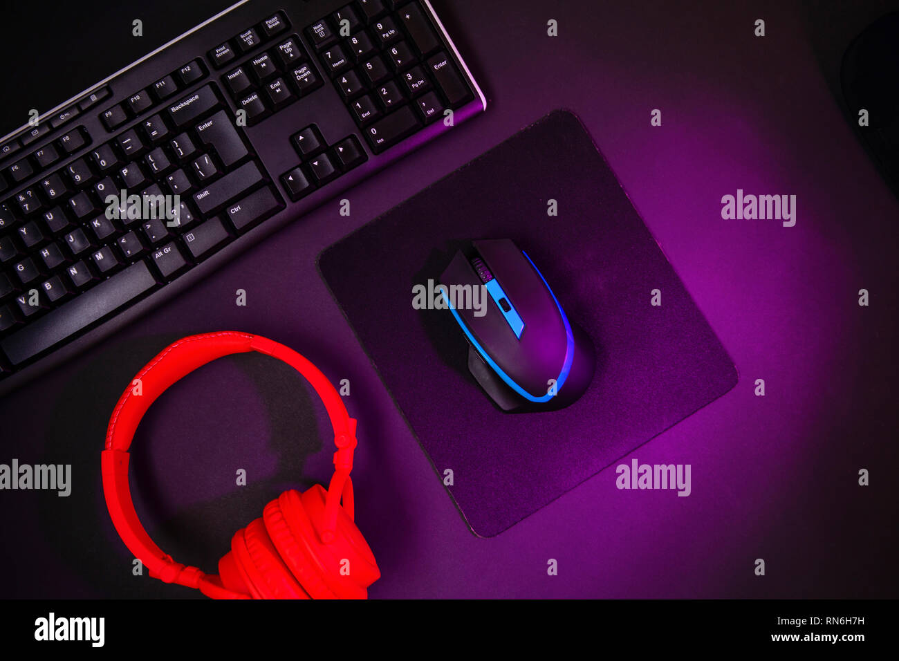 Top view a gaming gear, mouse, keyboard, joystick, headset, VR Headset on black table background. Stock Photo
