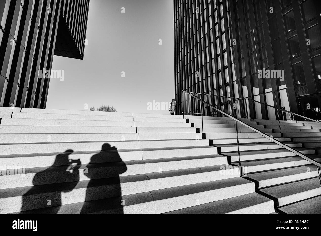 Duesseldorf, GERMANY - January 20, 2019: Modern architecture of New Harbour City throws long and dramatic shadows during sunset captured in B W. Stock Photo