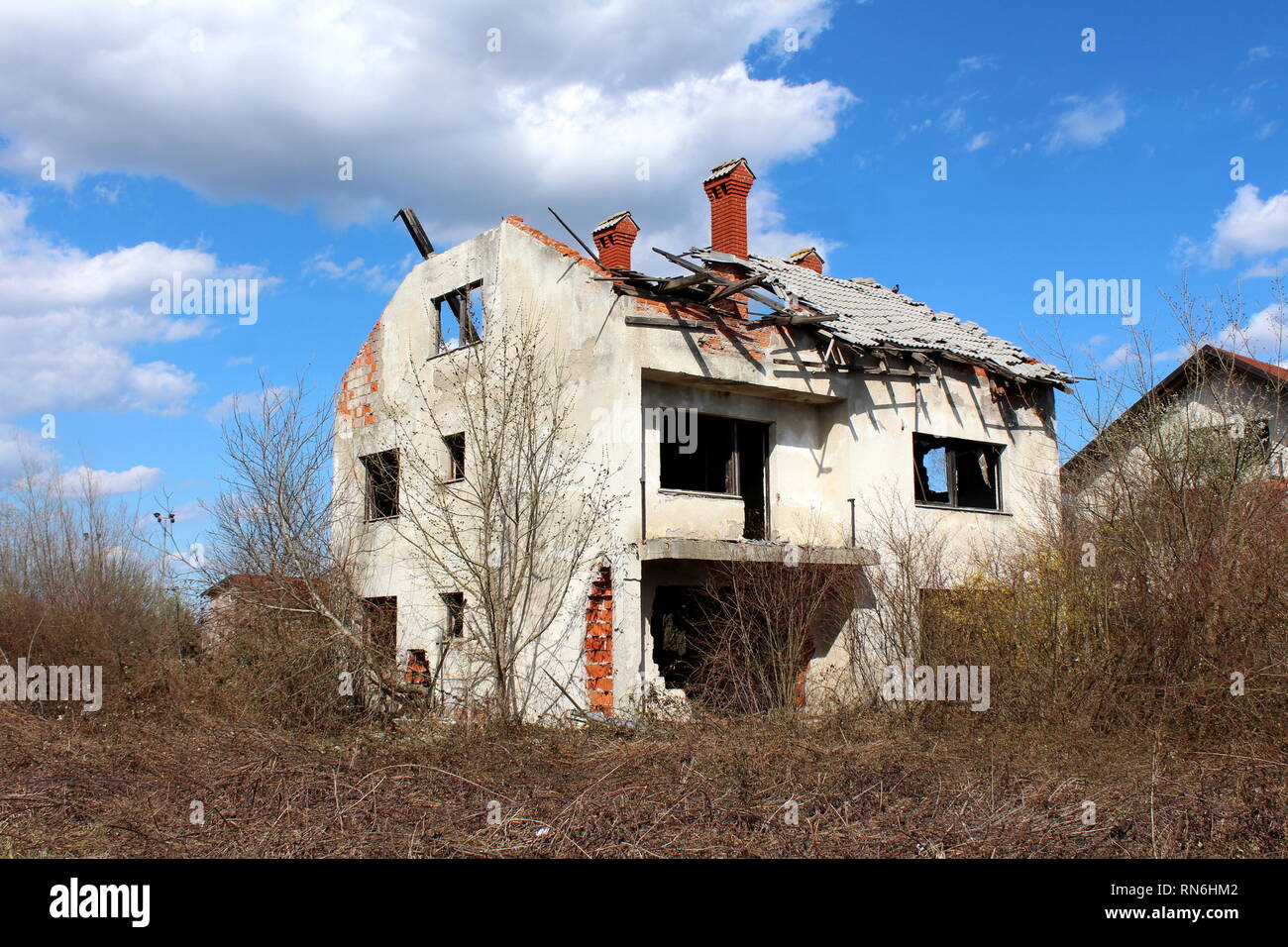 Damaged family house during war with missing windows and completely