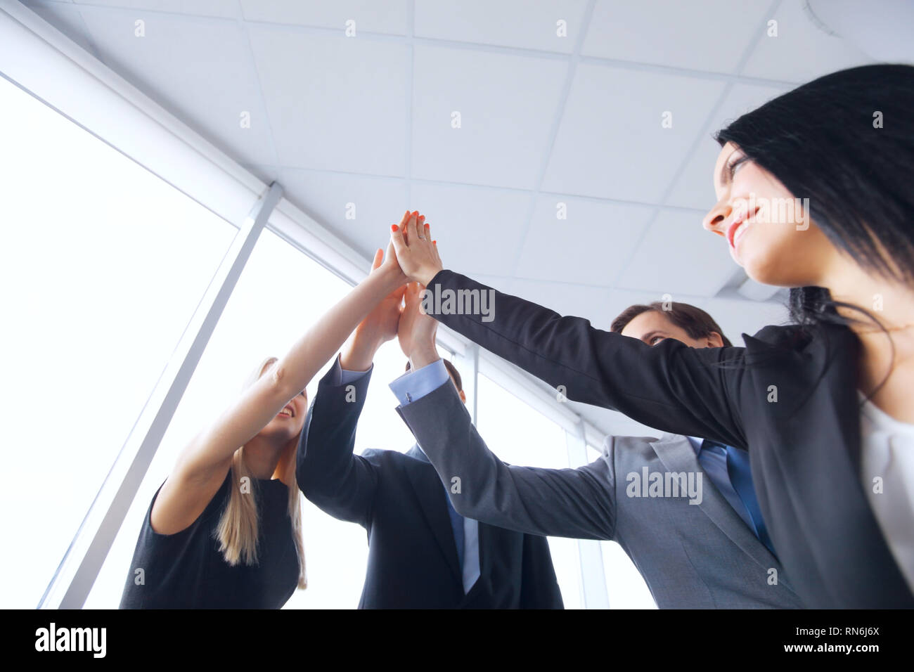 Happy business team giving high five in office , success and winning ...