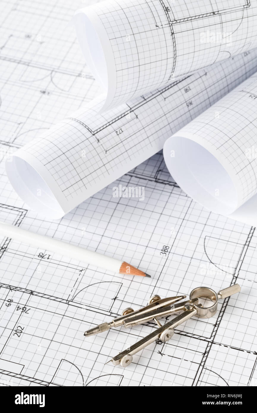 Rolls of architectural blueprint house building plans on blueprint background on table with pencil and compasses Stock Photo