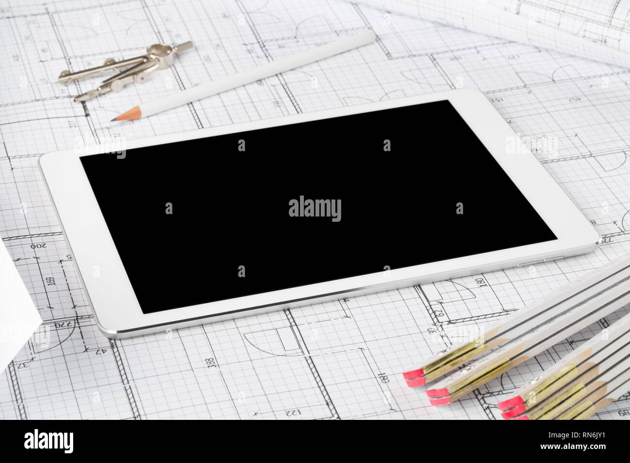 Tablet pc architectural blueprint house building plan with pencil, compasses and folding rule Stock Photo