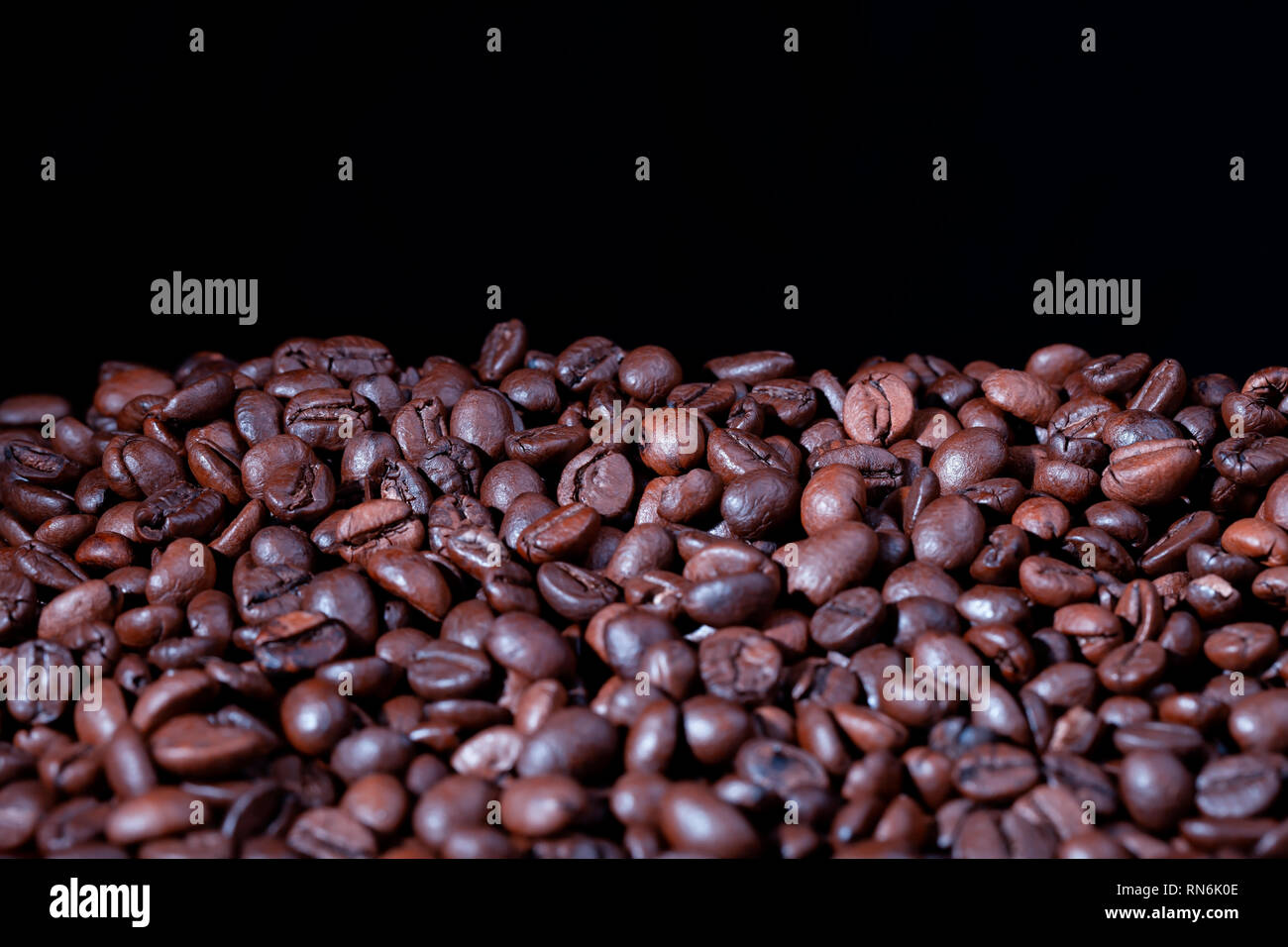 A pile of roasted coffee beans with black background Stock Photo - Alamy