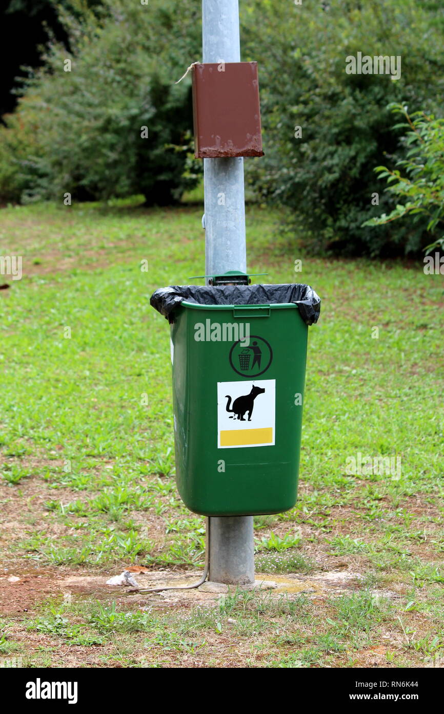 Metal pole with mounted box and trash can for garbage and dog waste
