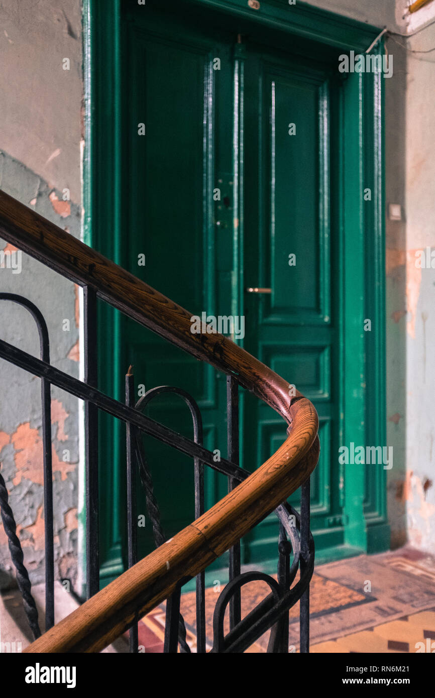 Period staircase for an apartment block leading to a green door Stock Photo