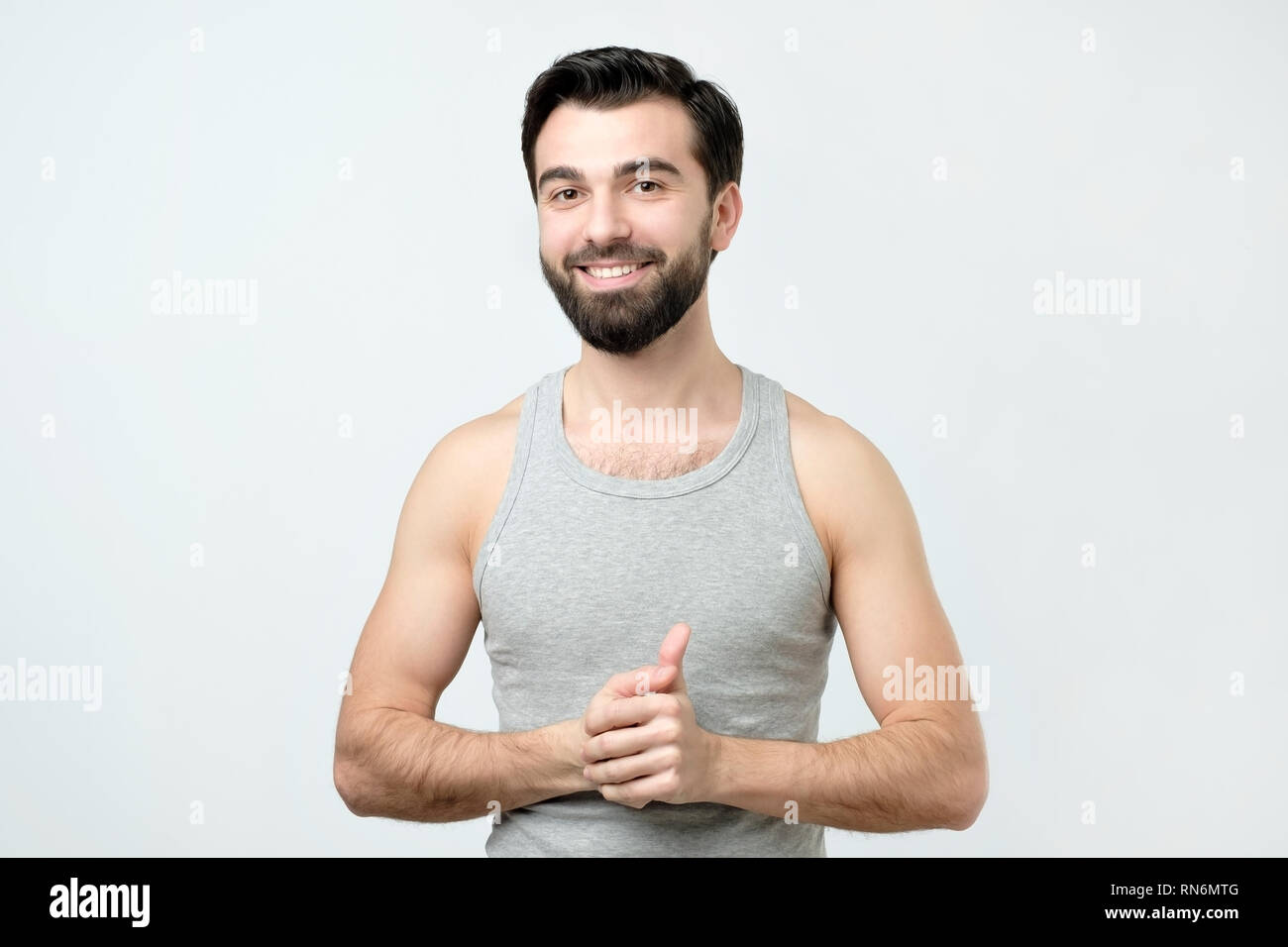 Smiling handsome man in singlet standing smiling Stock Photo
