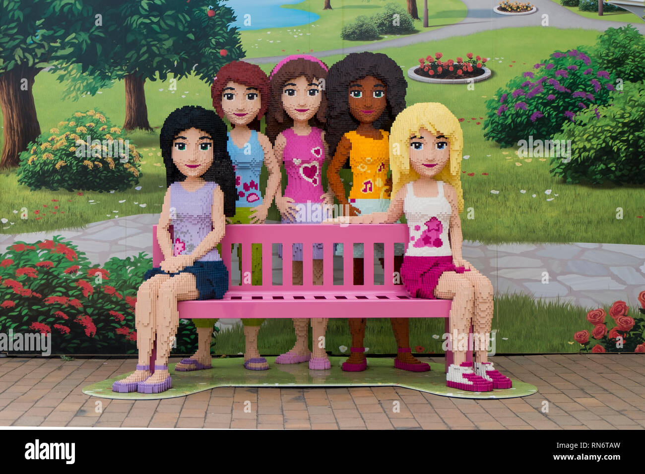 A group of young Lego girls surround a pink bench at Legoland Billund resort in Denmark. Stock Photo