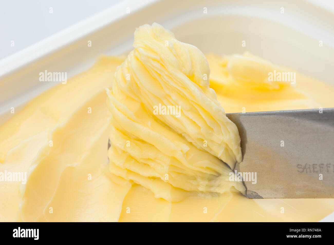 Knife in spreadable butter dish Stock Photo