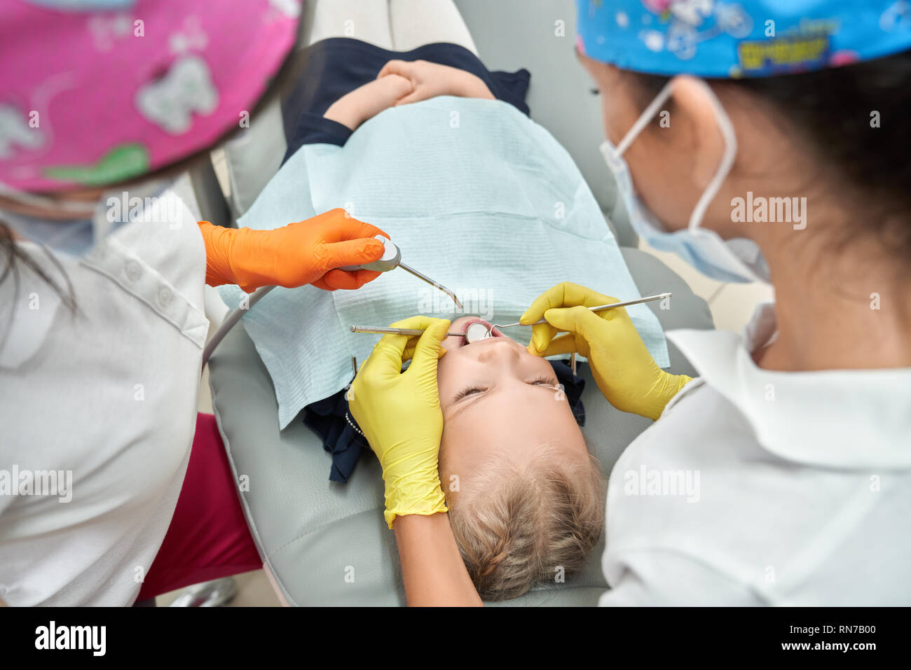 Dentists working with little patient in dentistry. KId lying on dentist
