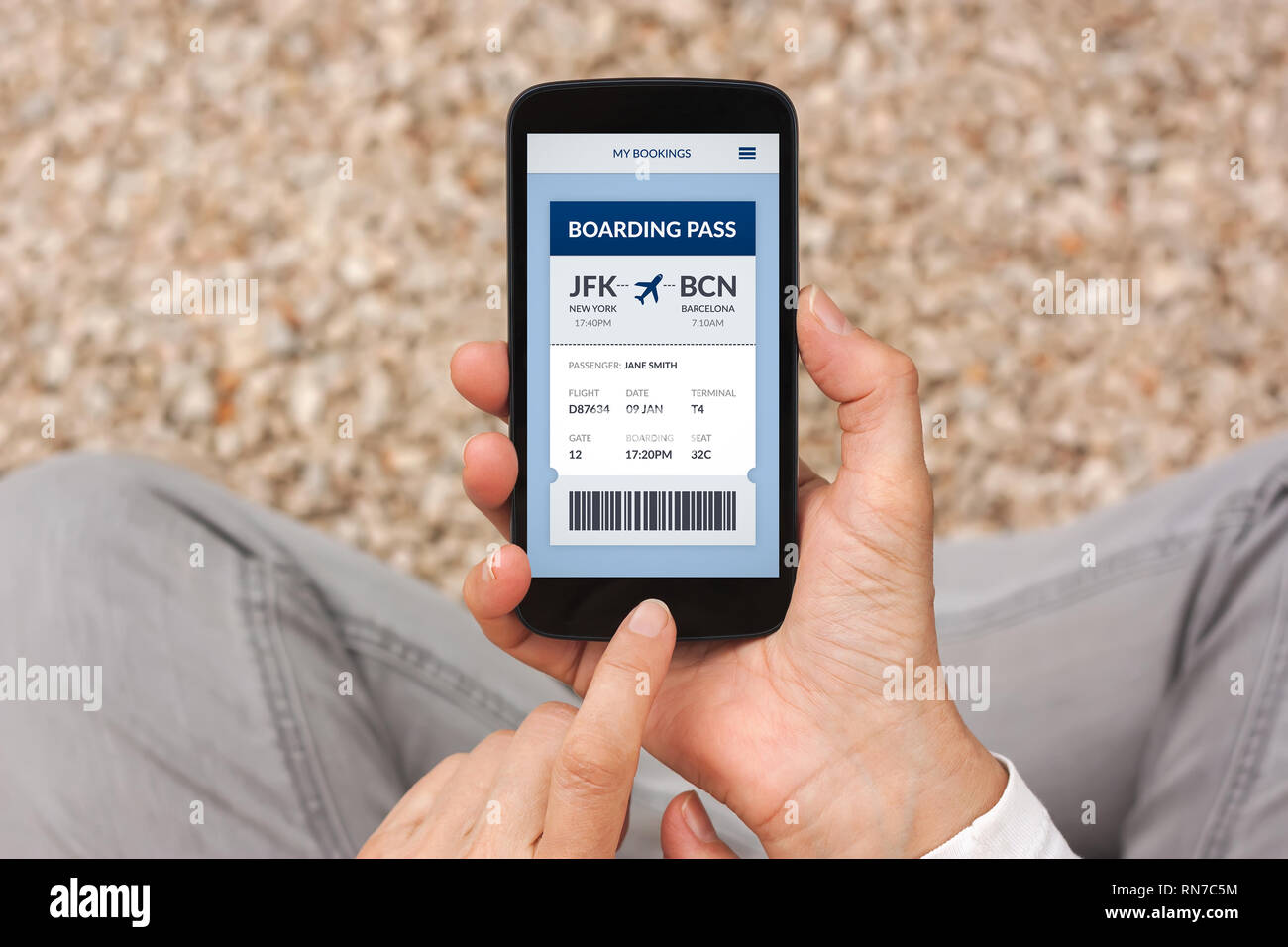 Hands holding smart phone with boarding pass concept on screen. All screen content is designed by me. Flat lay Stock Photo
