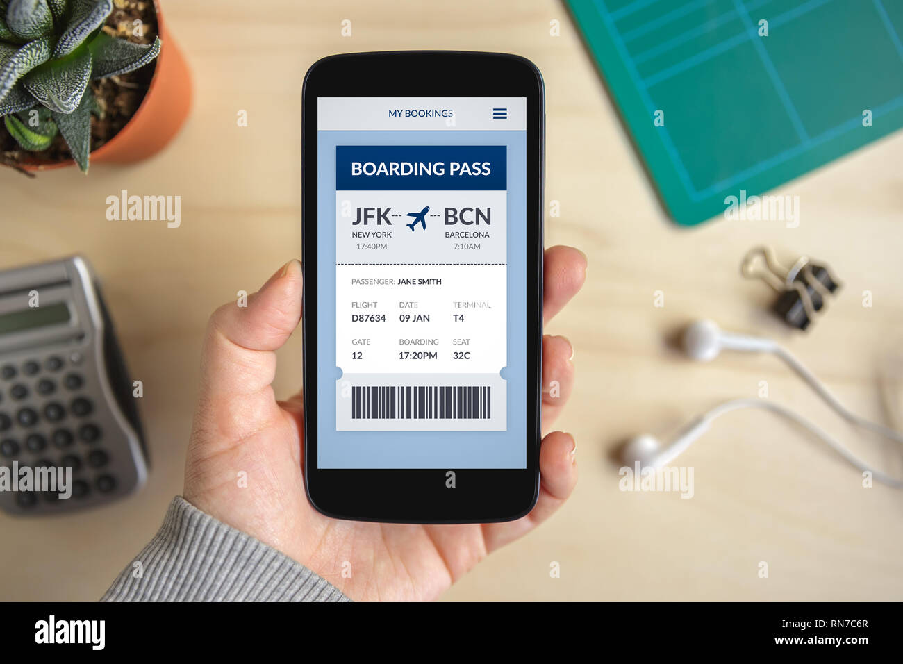 Hand holding smart phone with boarding pass concept on screen. All screen content is designed by me. Flat lay Stock Photo