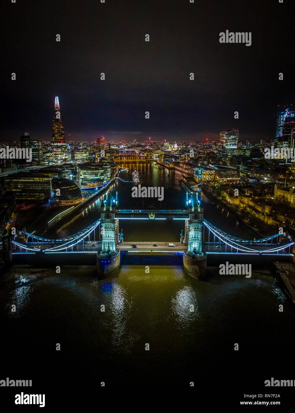 Night drone shot of Tower Bridge, with views of The Shard, London City Hall. Stock Photo