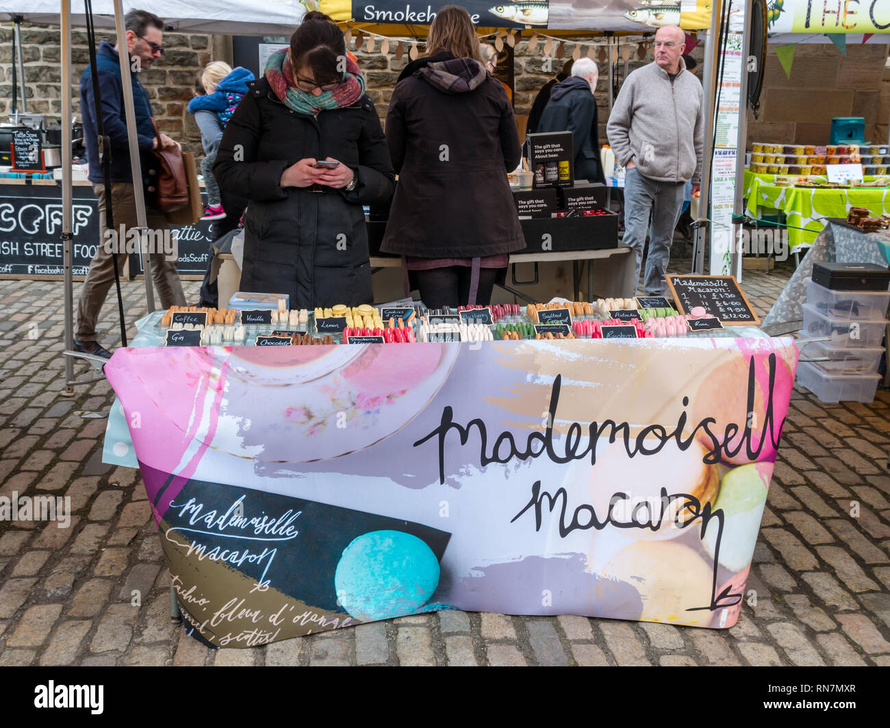 Woman stall holder, Mademoiselle Macaron biscuits, Leith Saturday market, Dock Place, Edinburgh, Scotland, UK Stock Photo