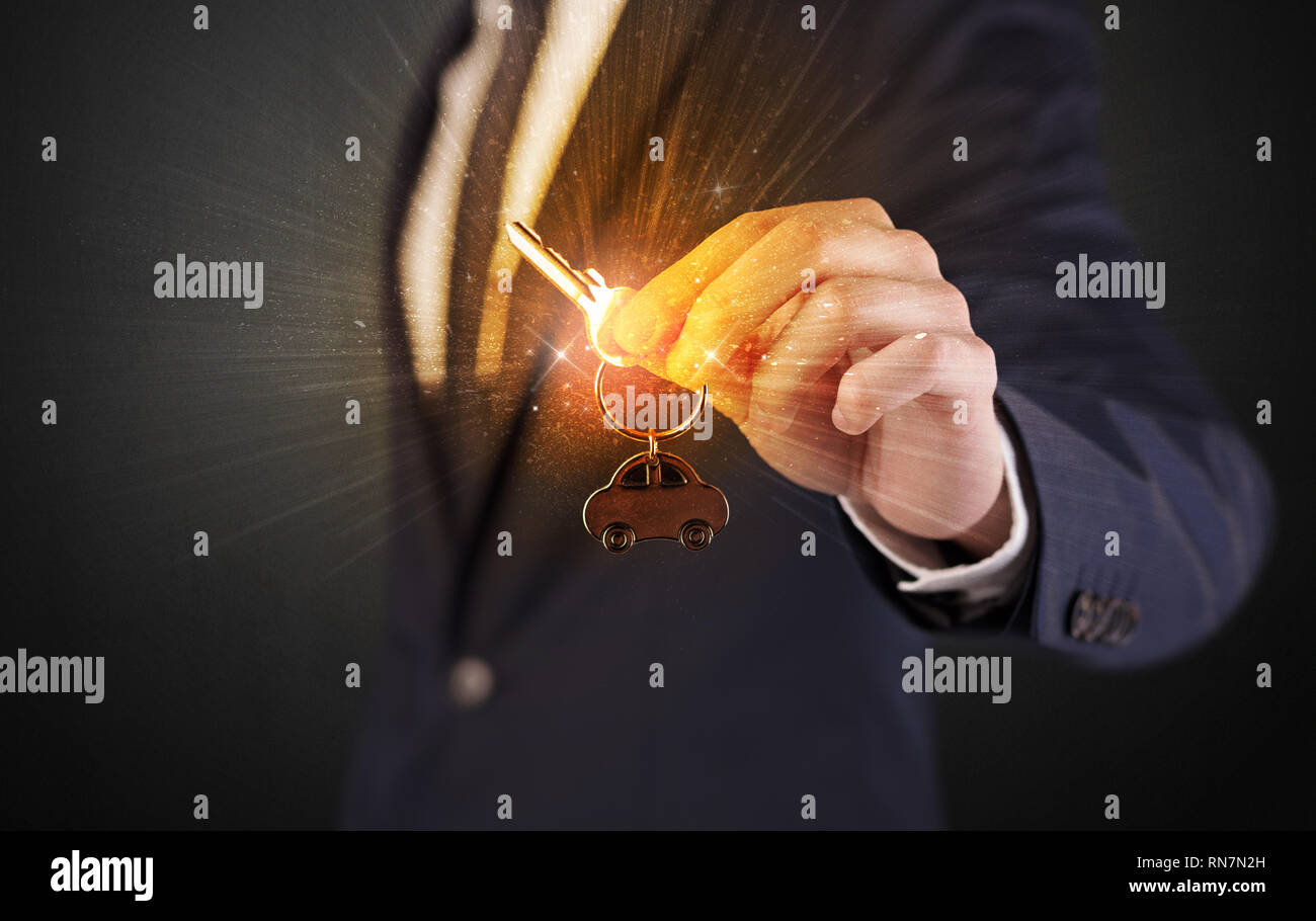 Formal man hand over shiny keys with dark background  Stock Photo