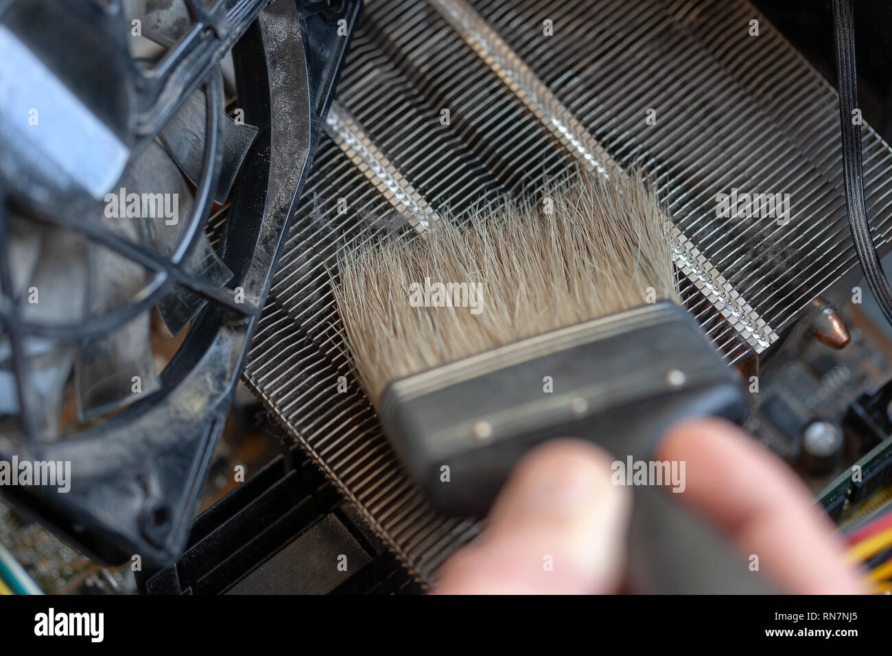 Cleaning A Radiator With A Brush From Dust Stock Photo - Download