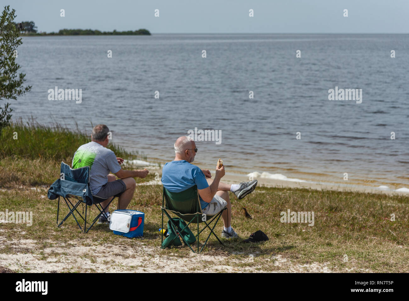 Two men in chairs at Bird Creek Beach in Yankeetown, Florida enjoying