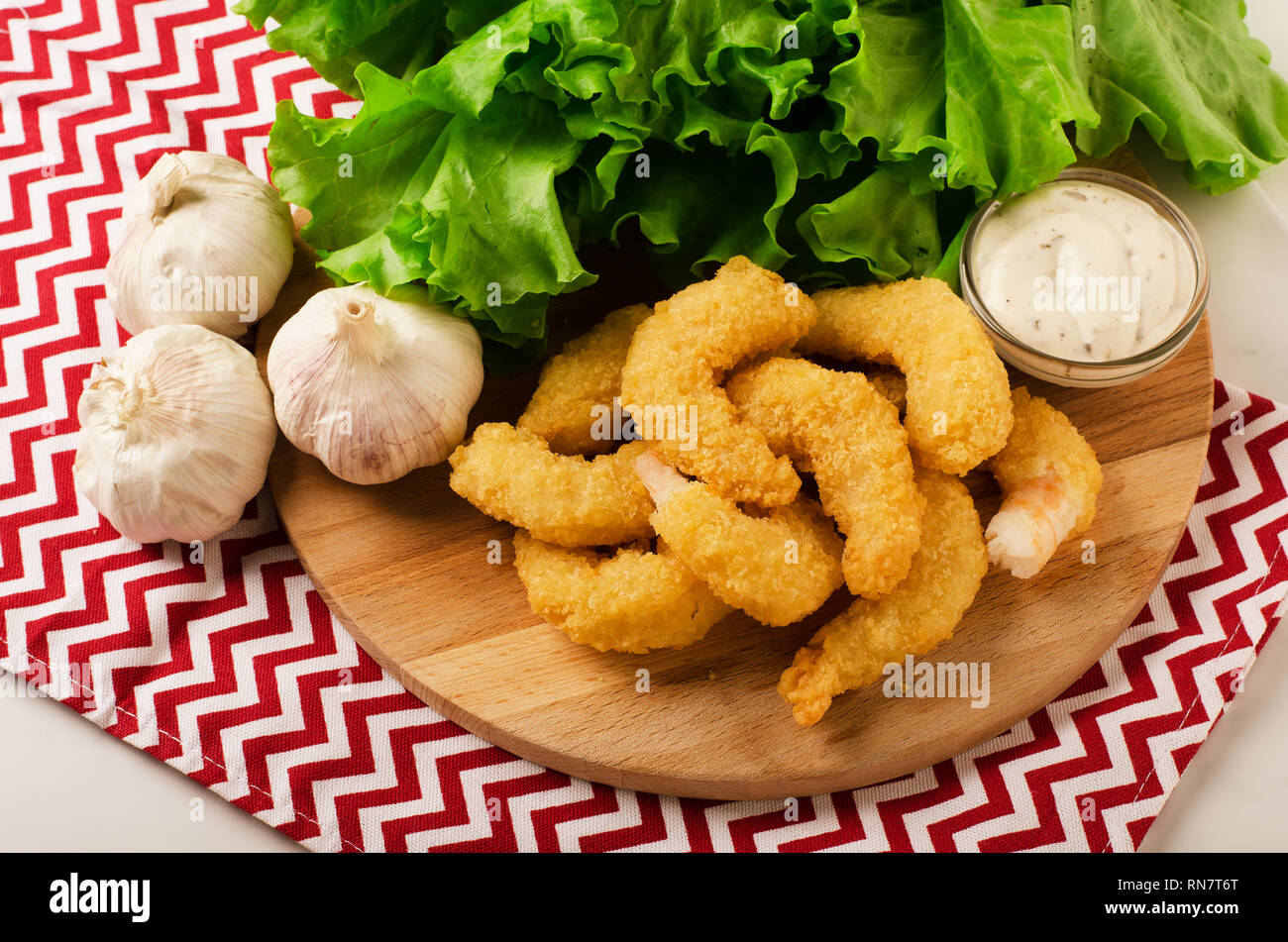 Fried organic coconut shrimp in breading with cocktail sauce and salad Stock Photo