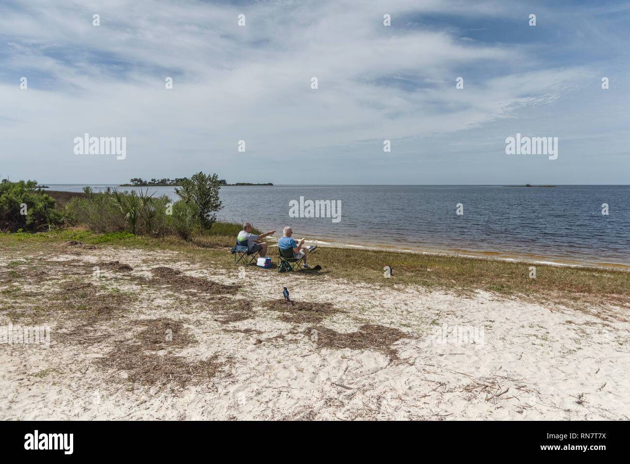 Two men in chairs at Bird Creek Beach in Yankeetown, Florida enjoying