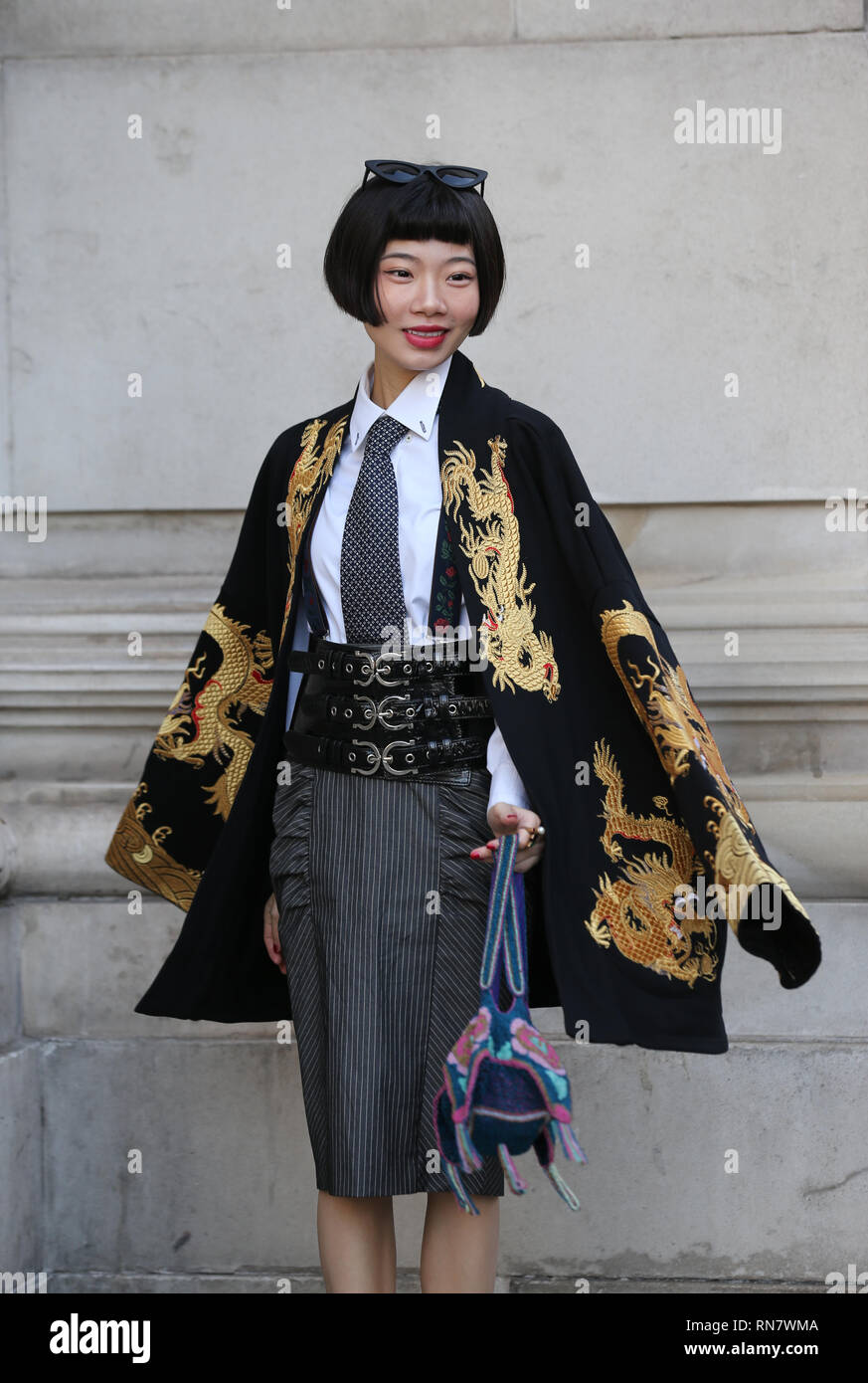 A fashionista wearing an oriental themed jacket during the Autumn/Winter 2019 London Fashion Week outside Freemasons' Hall, London. Stock Photo