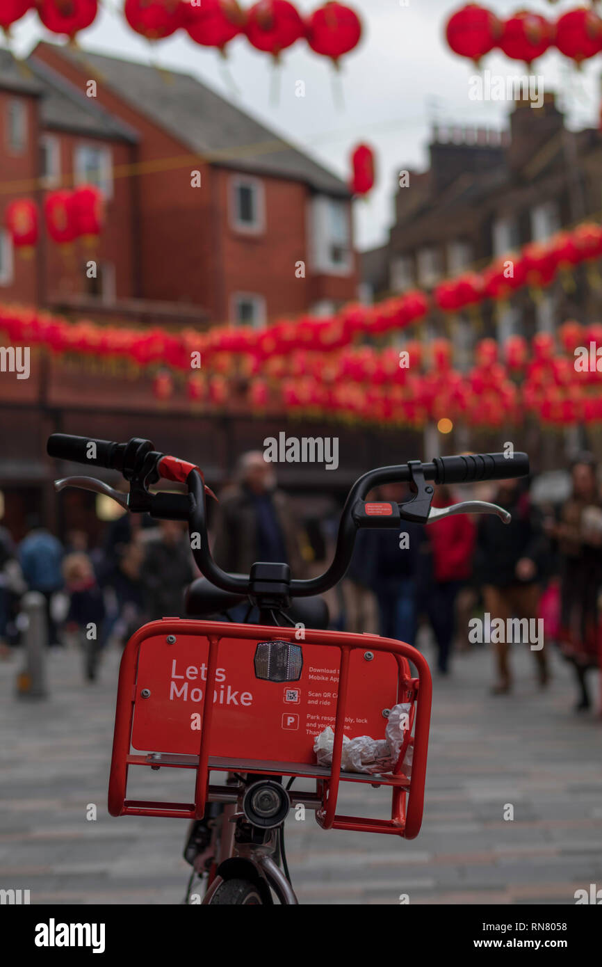 Chinatown in Soho are London. Red electro bike matching the color contrast with Chinatown baloons. Stock Photo