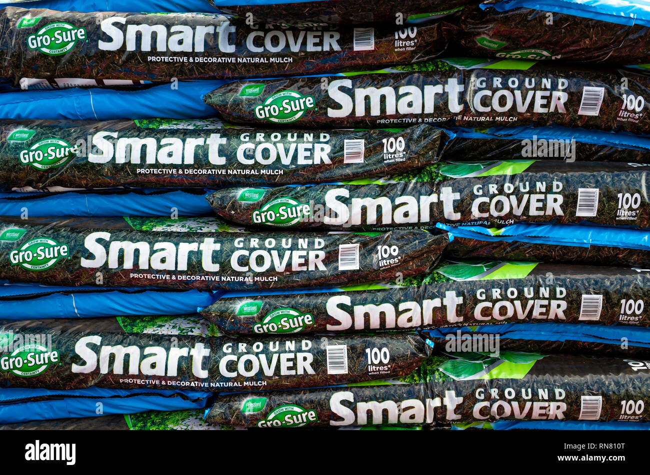 A stack of bags of Smart Ground Cover decorative mulch in a garden centre Stock Photo