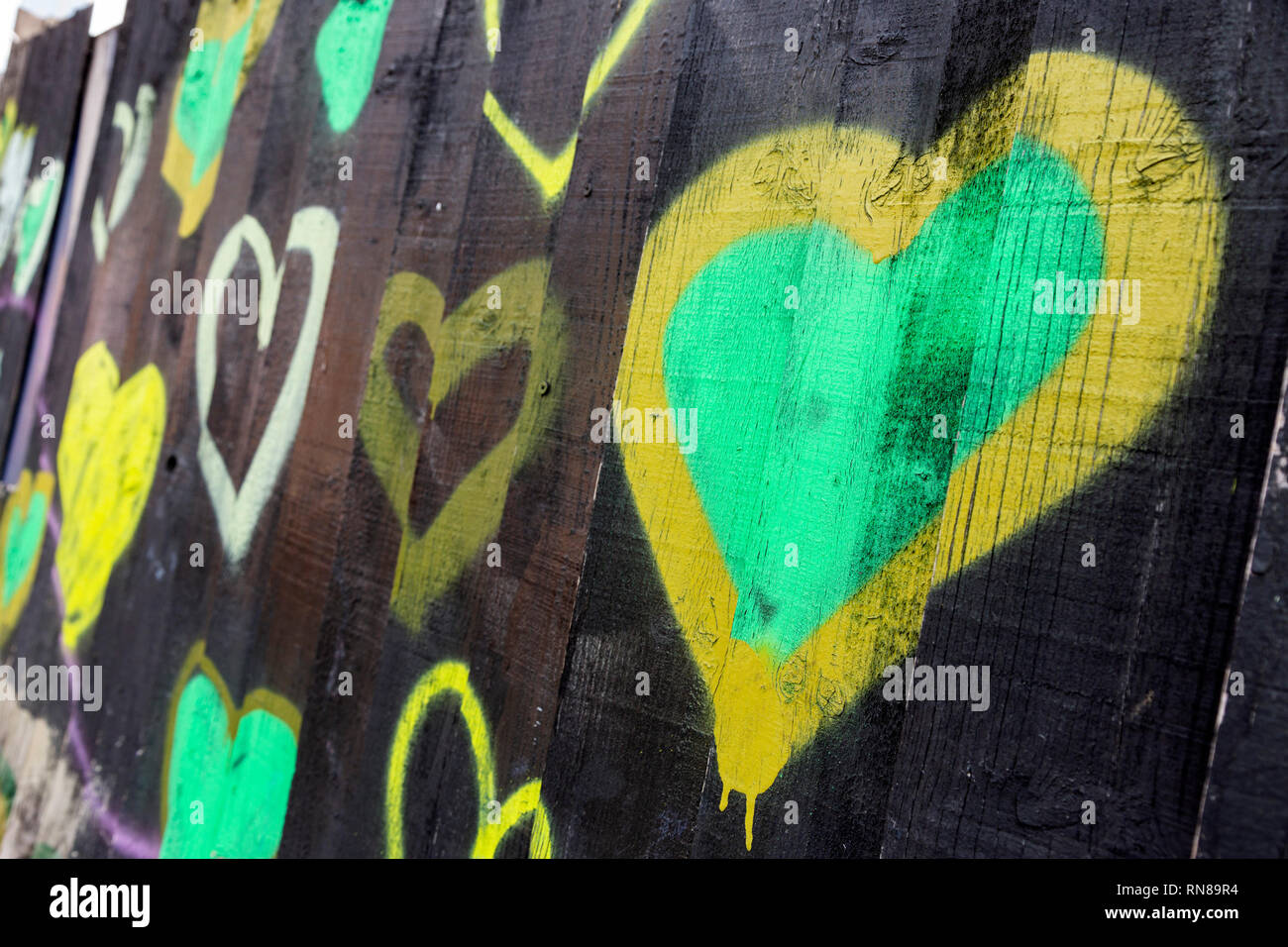 Black Fence with Green Hearts, Grenfell Tower Memorial, Notting Hill, London, England, United Kingdom, UK Stock Photo