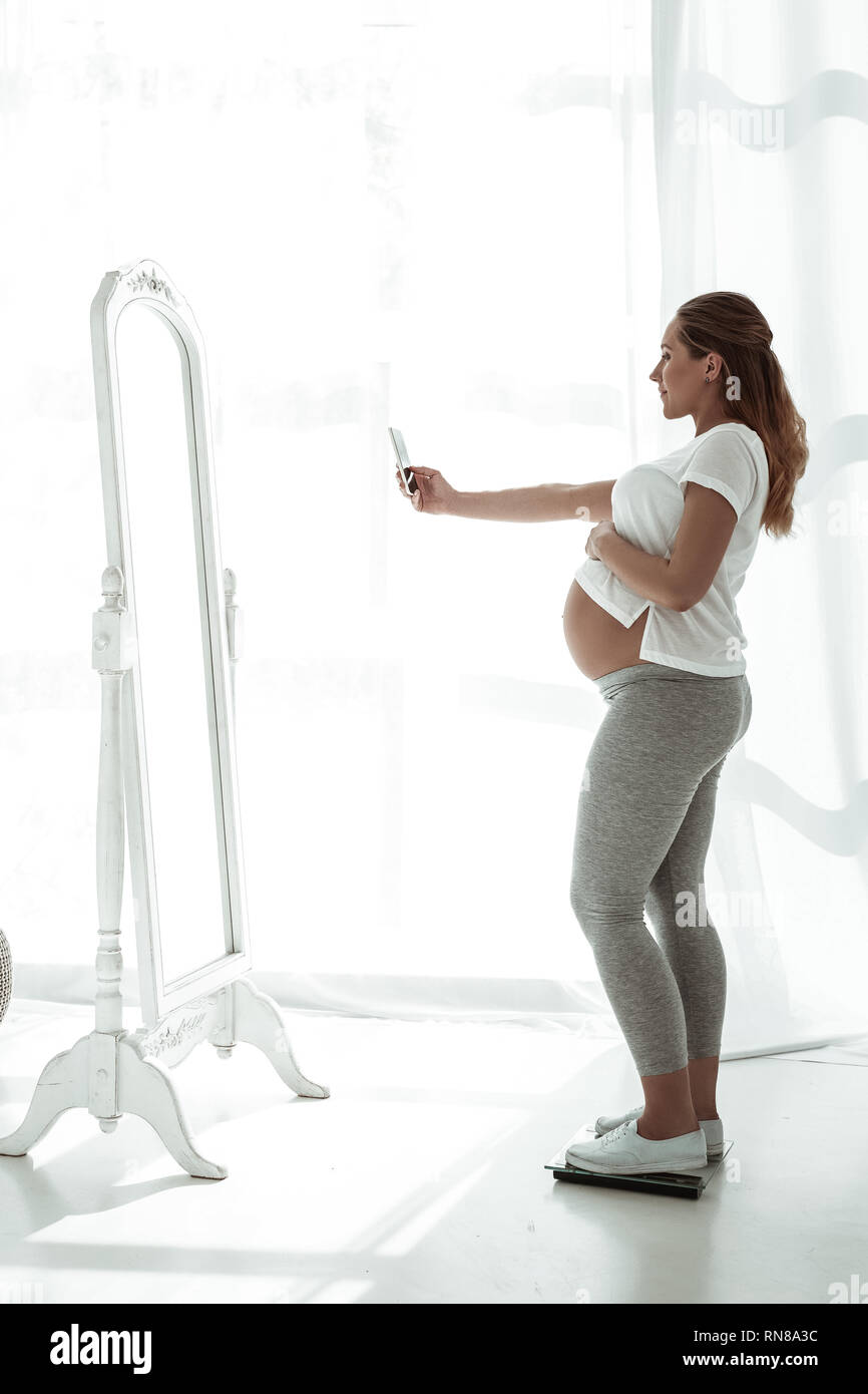 Pregnant woman in front mirror hi-res stock photography and images - Alamy