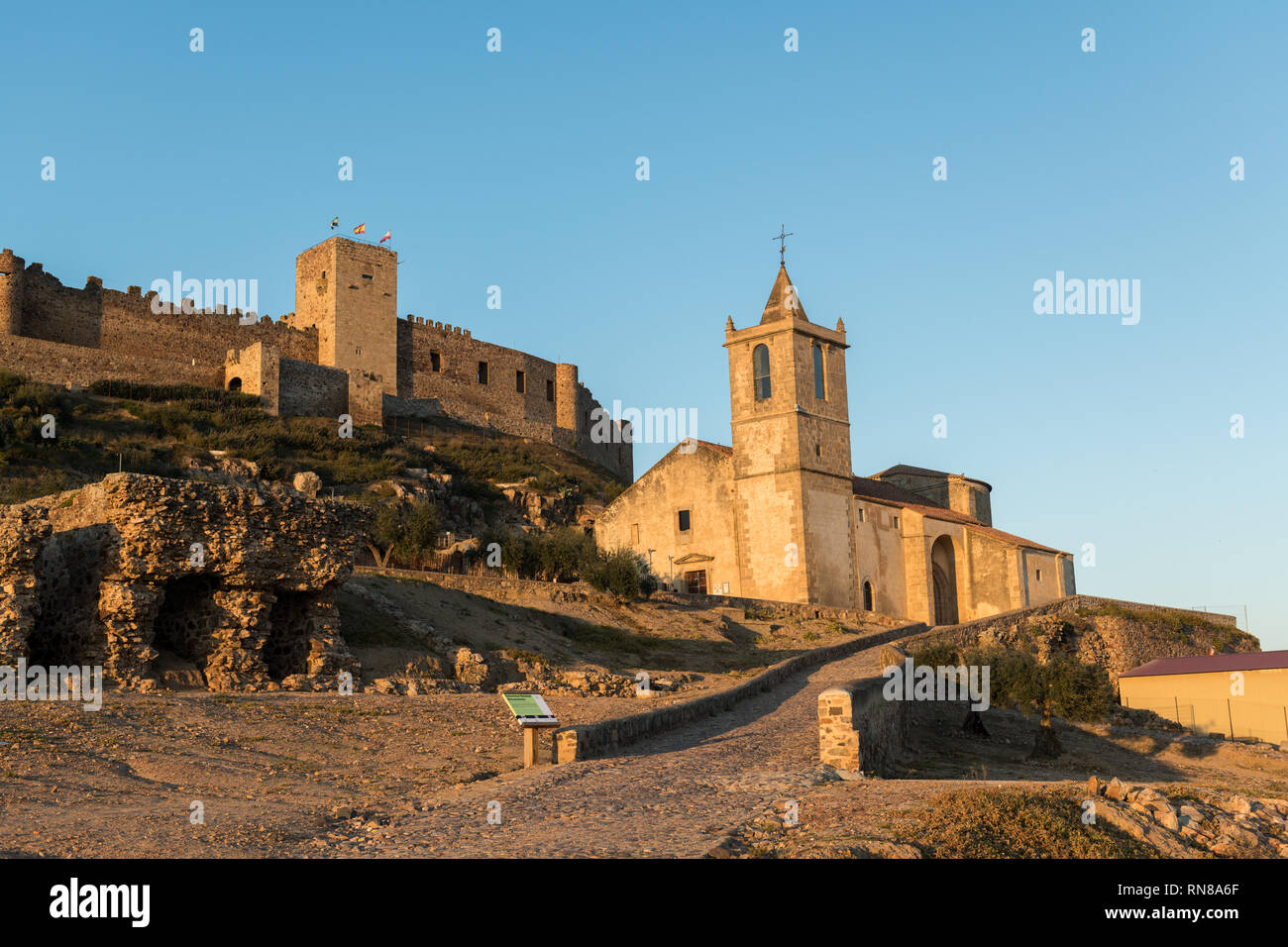 The church of Santiago Apostol and the castle of Medellin seen at sunset Stock Photo