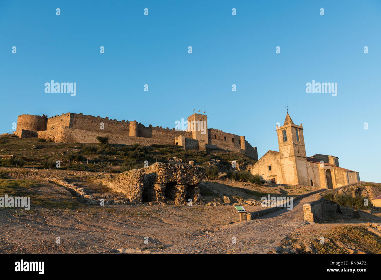 The church of Santiago Apostol and the castle of Medellin seen at sunset Stock Photo