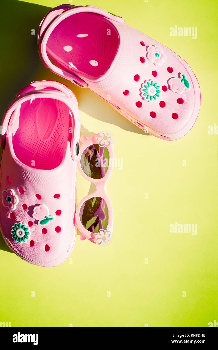 Baby Pink slippers with sunglasses on yellow background.Rubber beach ...