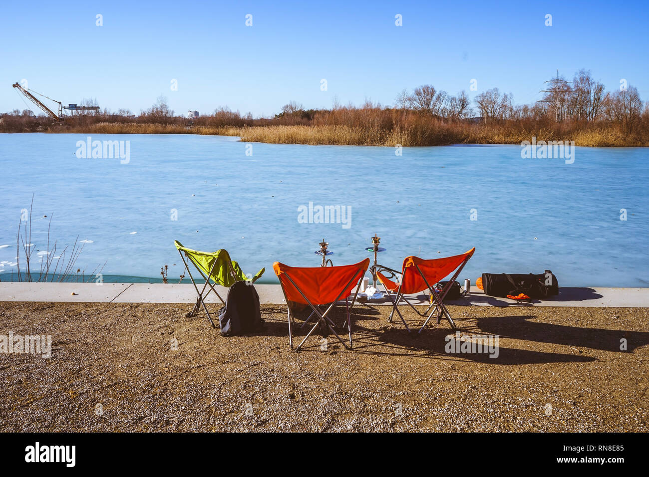 Sunny day on the frozen lake with camping chairs Stock Photo