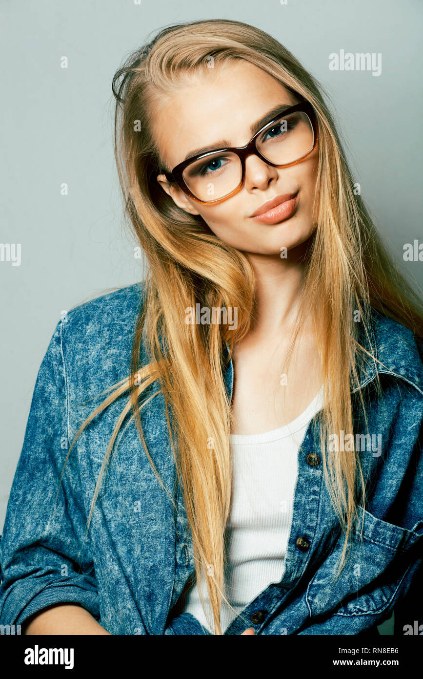 young pretty girl teenager in glasses on white isolated blond hair